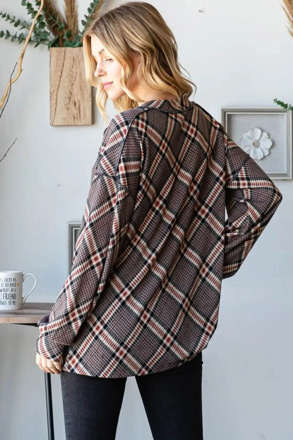 Woman wearing Heimish plaid exposed seam V-neck t-shirt with brown and beige checkered pattern, styled casually with black pants.