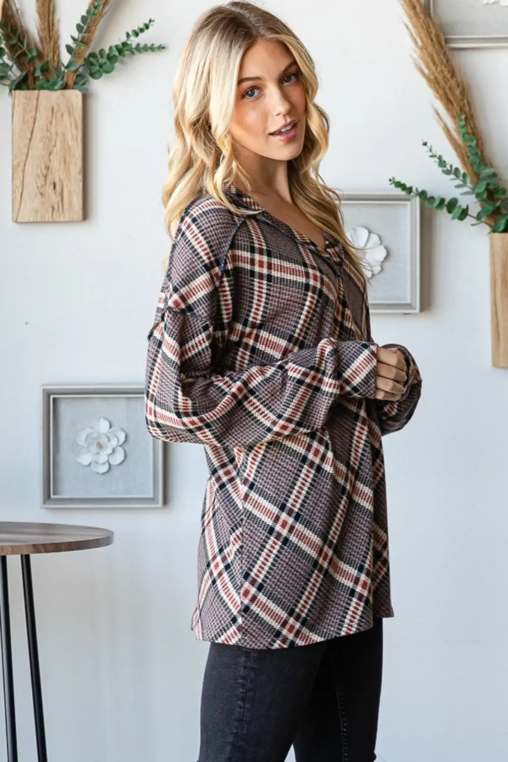 Woman wearing Heimish plaid exposed seam V-neck t-shirt with long sleeves and casual fit in a bright room setting