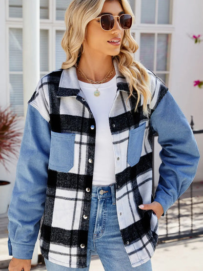 Woman wearing pocketed plaid snap down denim jacket with black and white check pattern and blue sleeves outdoors