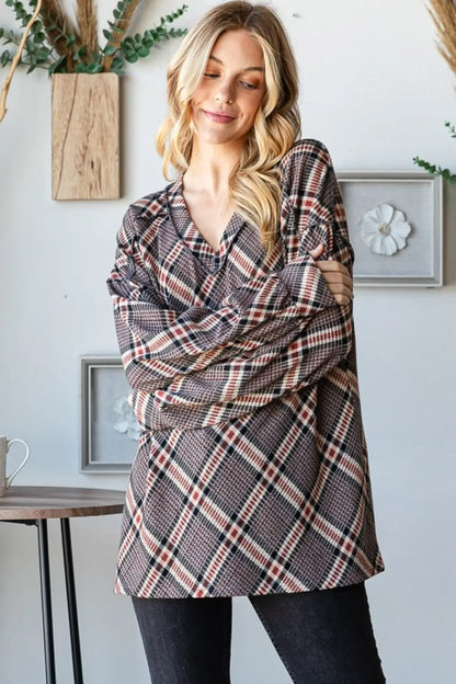 Woman wearing Heimish plaid exposed seam V-neck t-shirt styled casually with black pants in a modern interior setting